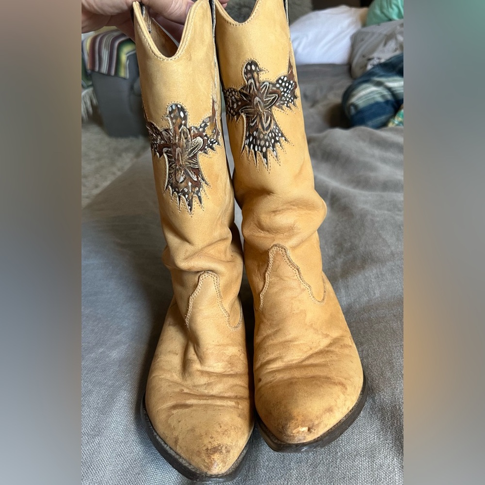 Tan, calf high cowboy boots. Feather detailed Firebird symbol cut into the boot.